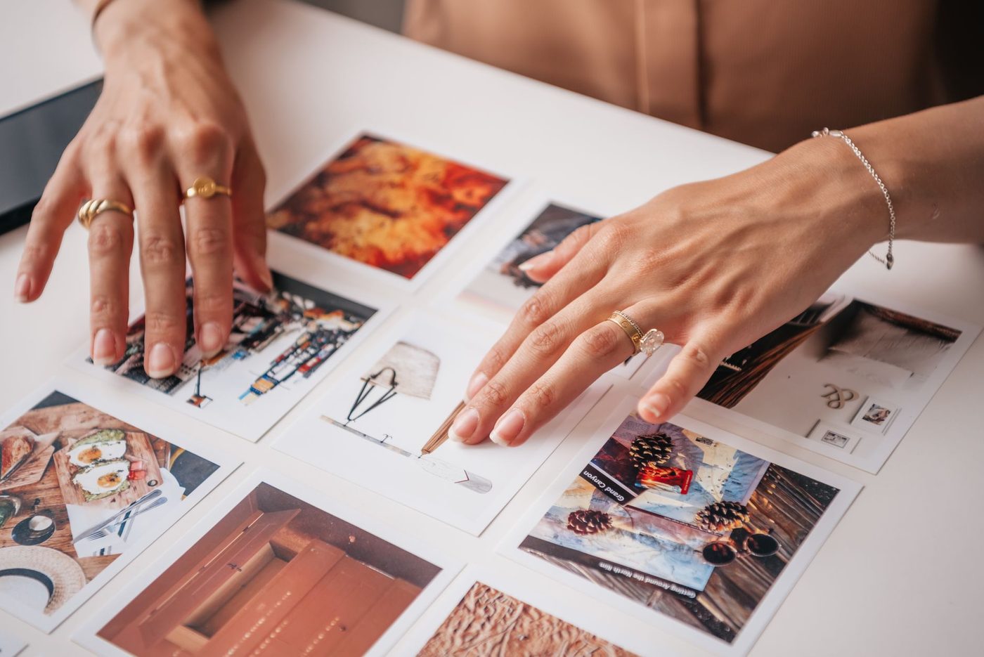 Handen schuiven afgedrukte foto's op tafel om een keuze te maken