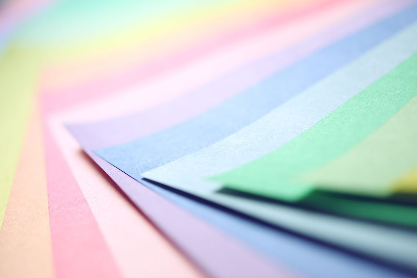 Vellen papier in pasteltinten liggen in lagen over elkaar