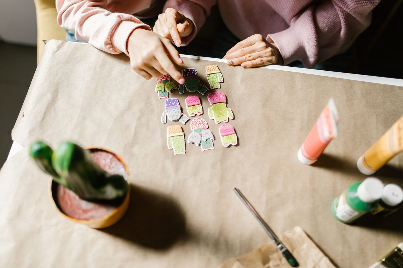 Meerdere handen leggen papieren knipsels op een gedeelde werktafel